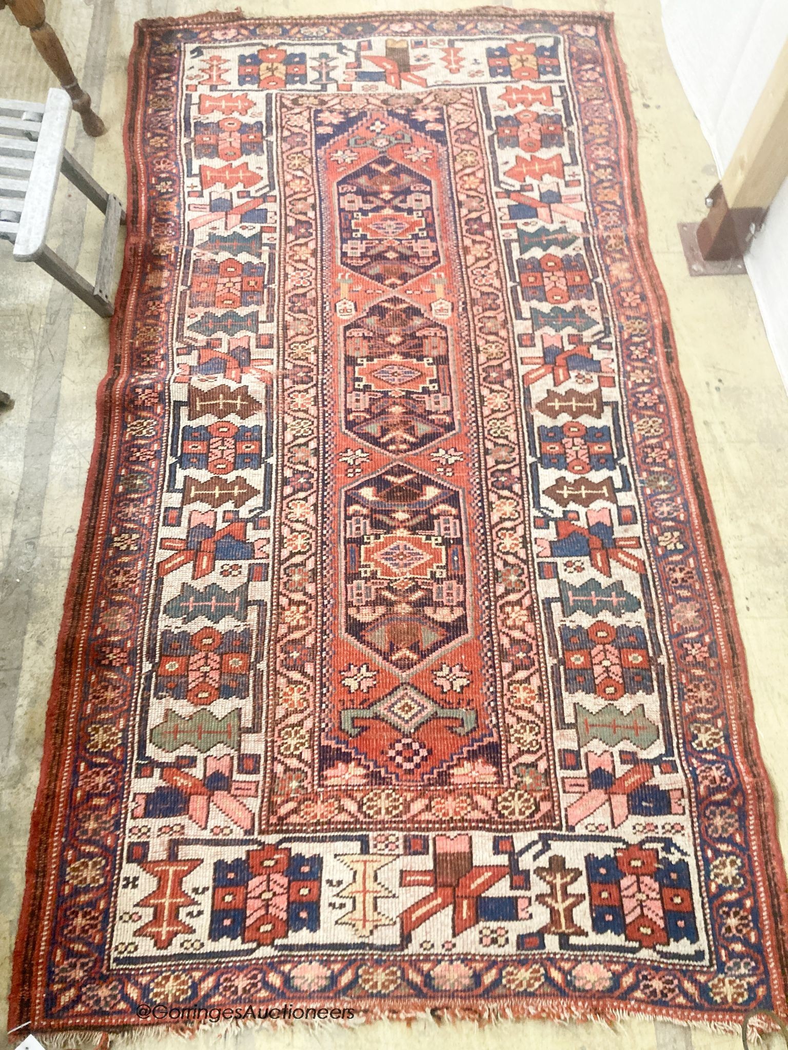 A Caucasian red ground rug, 218 x 112cm